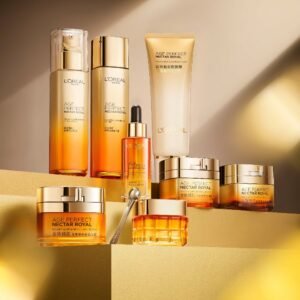A collection of L'Oréal Paris Age Perfect Nectar Royal golden skincare products (creams, serums, and cleansers) displayed on stepped gold platforms.